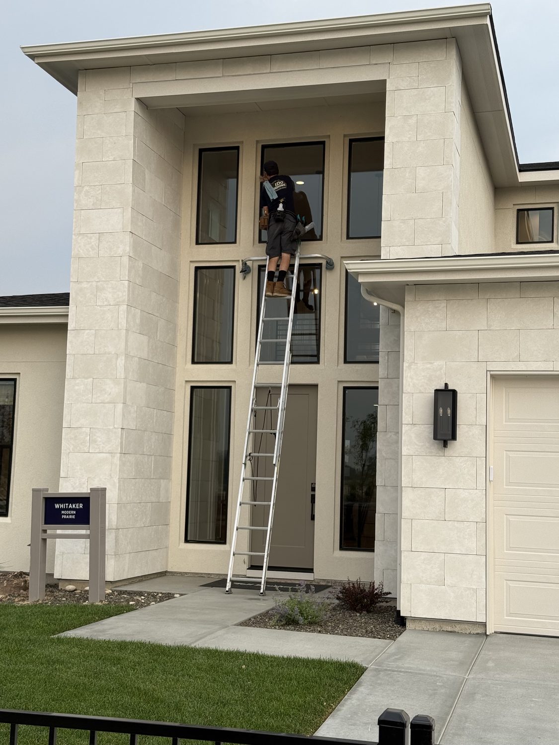 Technician cleaning a two-story home's windows in the Treasure Valley